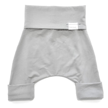 Taupe grow-with-me shorts for kids, made from soft organic cotton with a stretchy, foldable waistband. Ethically made in Canada for a sustainable and comfy fit.