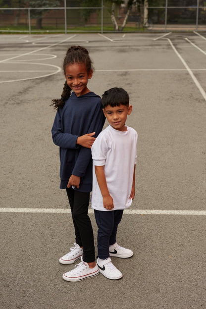 White grow-with-me t-shirt for kids, made from soft organic cotton with a stretchy, foldable waistband. Ethically made in Canada for a sustainable and comfy fit.