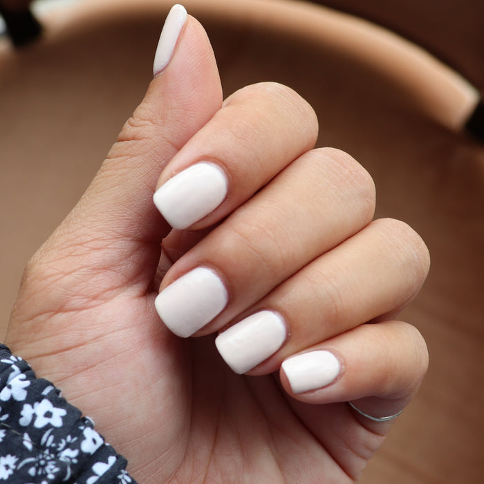 Hand with nails painted in HGC creamy toasted neutral shade for a soft, warm, and long-lasting manicure look