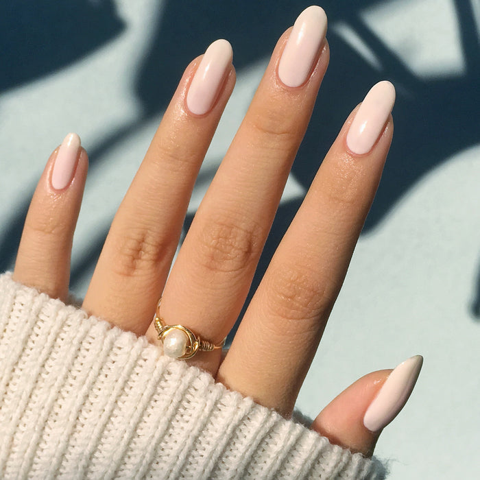 Hand with nails in HGC creamy toasted neutral polish for a soft, warm, and durable manicure look