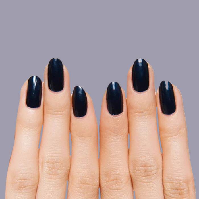 Close-up of hands with nails painted in deep shimmering inky navy using HJ for a polished manicure look