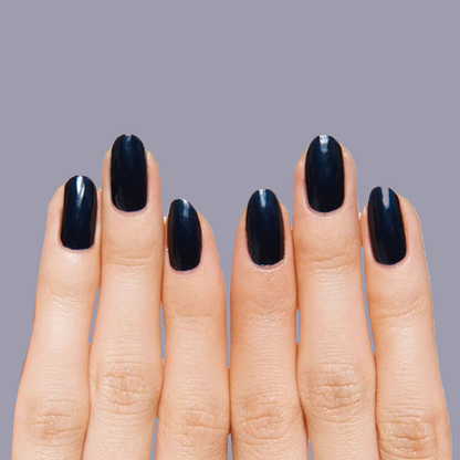 Close-up of hands with nails painted in deep shimmering inky navy using HJ for a polished manicure look