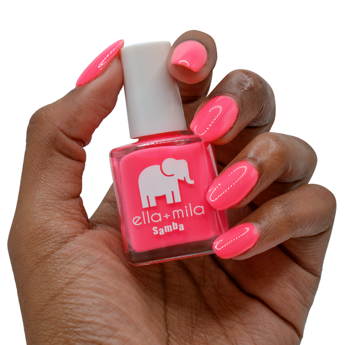 Island Love bright pink nail polish on a deep skin tone, hand holding the bottle