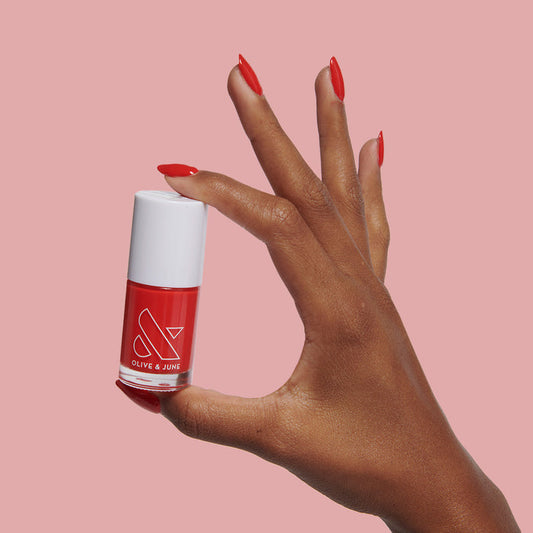 Hand with glossy cranberry Kiss Cam nail polish for a vibrant long-lasting mani and pedicure by Olive and June
