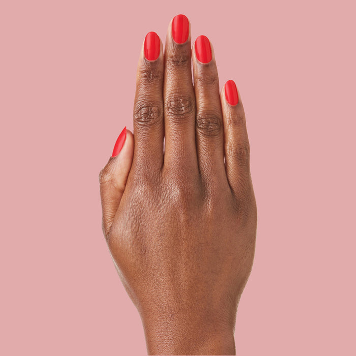 Hand with Kiss Cam polish in bright cranberry red for a vibrant, long-lasting manicure and at-home mani look
