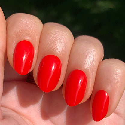 Hand with smooth, bright red Kiss Cam polish for a vibrant, long-lasting manicure by Olive and June