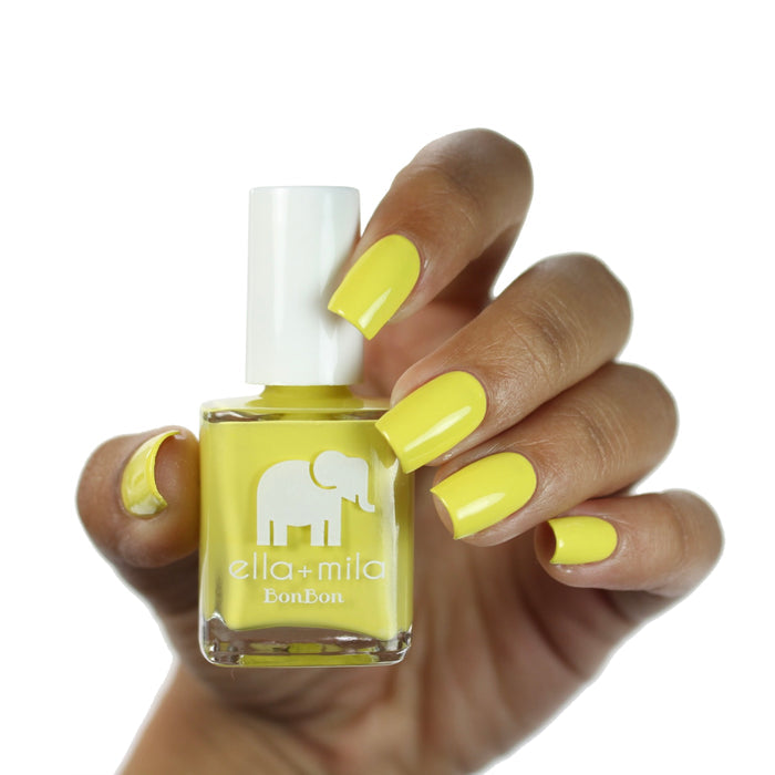 Limoncello mellow yellow nail polish on a deep skin tone, hand holding the bottle