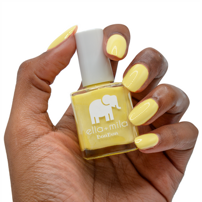 Limoncello yellow nail polish on a medium skin tone, hand holding the bottle