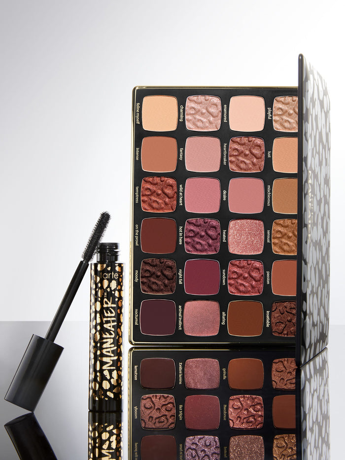 Makeup palette with various shades of eyeshadows and a mascara on a light gray background