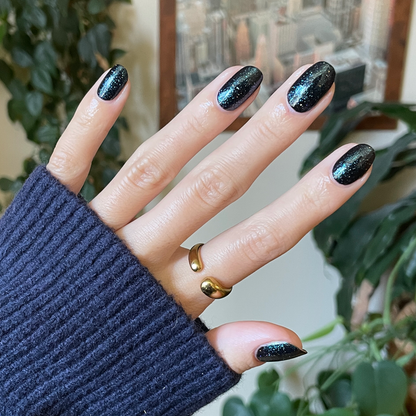 Meteor Shower quick dry polish on nails showing shimmering black base with sparkling topper for at-home manicure