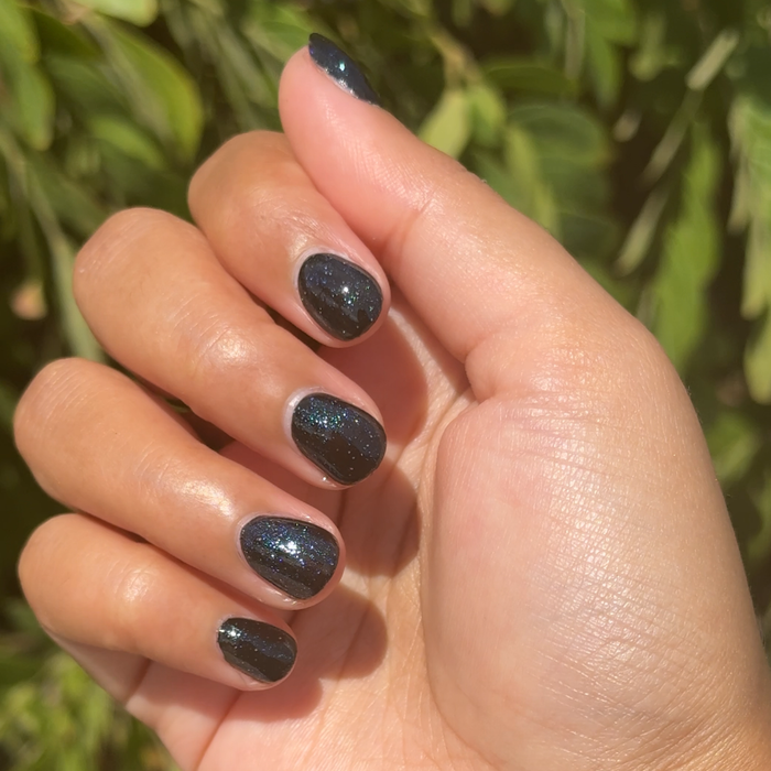 Meteor Shower manicure on short nails with shimmering black polish and sparkling glitter for an at-home mani look