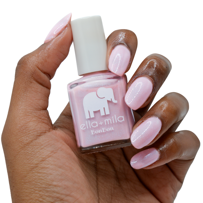 Midnight in Paris lavender pink nail polish on a deep skin tone, hand holding the bottle