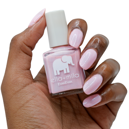 Midnight in Paris lavender pink nail polish on a deep skin tone, hand holding the bottle