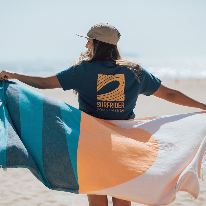 Back view of tee on a model at the beach.