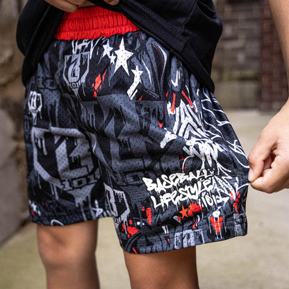 Youth model wearing gray youth shorts with “Night Game Drip” design