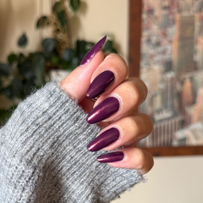 On the Promenade shimmering mulberry purple gel polish on almond-shaped nails for a chic at-home manicure look