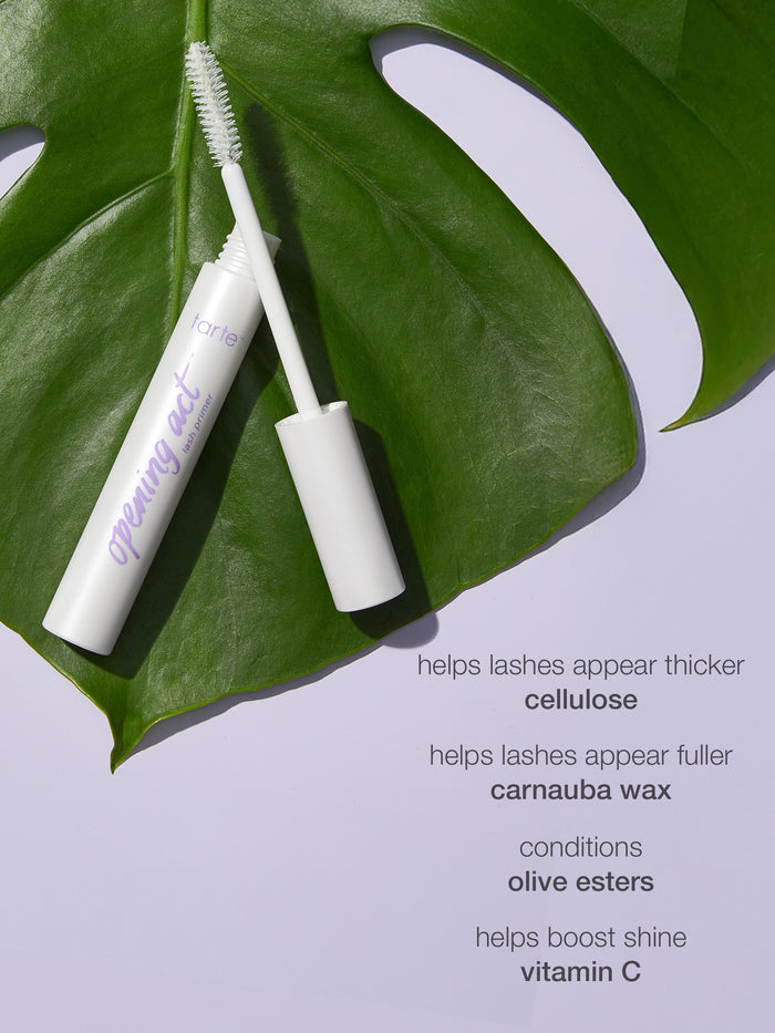 Mascara tube with brush on a green leaf against a light purple background