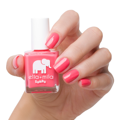 Pinktini coral pink nail polish manicure on a light skin tone with the bottle