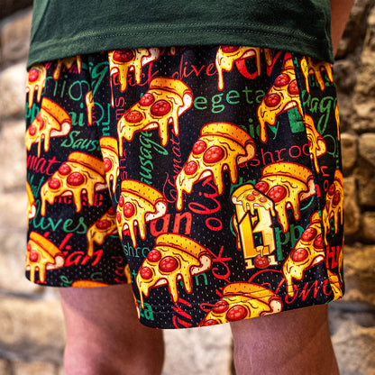 Youth model wearing multi-color youth shorts with “Pizza” design