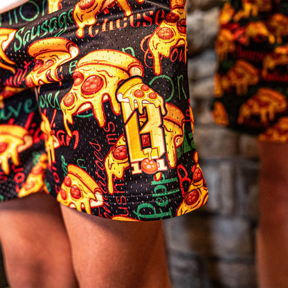 Youth model wearing multi-color youth shorts with “Pizza” design