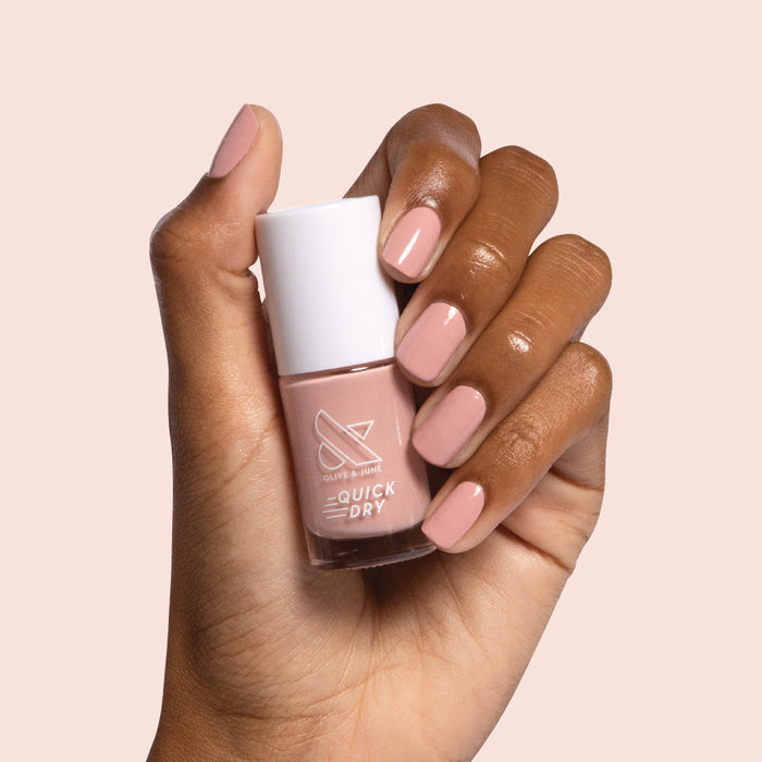 Hand holding bottle of Poodle nail polish with matching nails polished for a sophisticated at-home manicure look