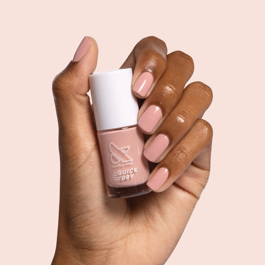Hand holding bottle of Poodle nail polish with matching nails polished for a sophisticated at-home manicure look
