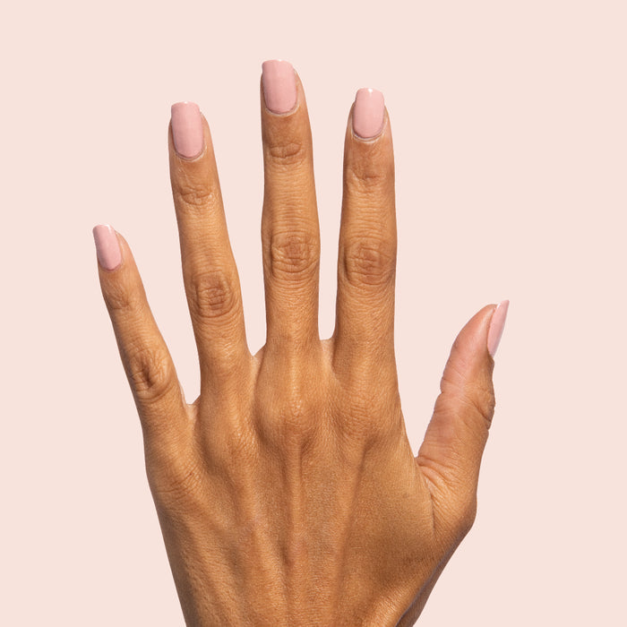 Hand showing nails painted in Poodle neutral beigey pink polish for a polished at-home manicure look