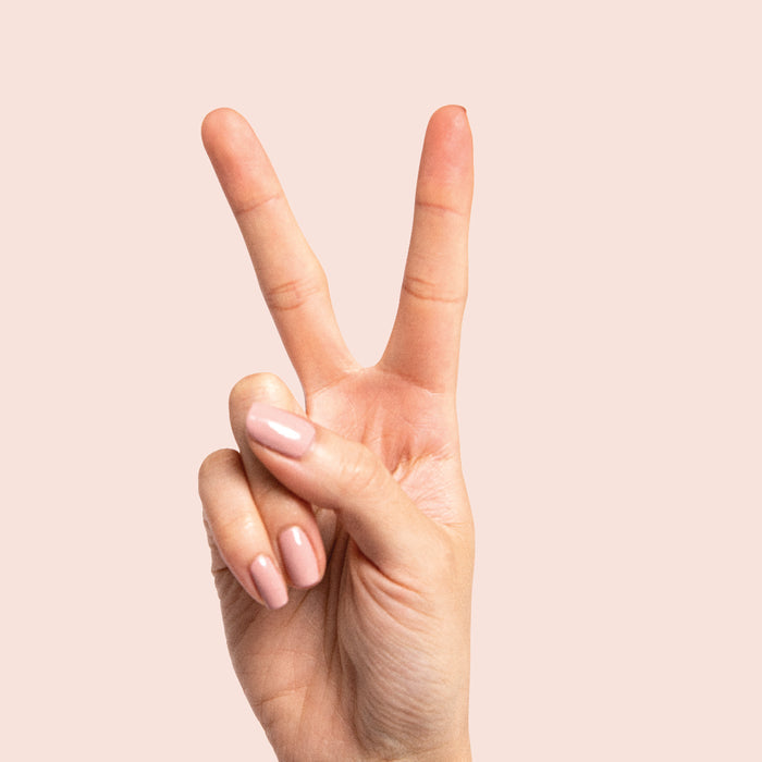 Hand showing nails painted in Poodle neutral beigey pink polish for a polished at-home mani look