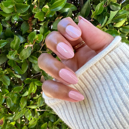Hand with nails painted in Poodle neutral beigey pink showcasing a smooth, polished at-home manicure look