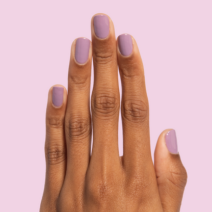 Hand with nails painted in soft blooming purple Prairie polish for a smooth, quick dry manicure by Olive and June
