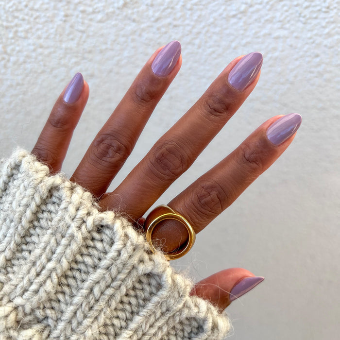 Hand with nails painted in soft purple Prairie polish featuring a smooth quick-dry manicure by Olive and June