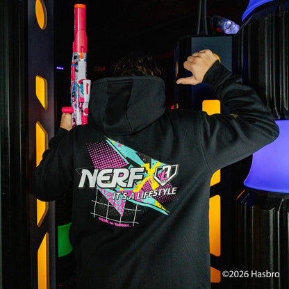 Person wearing a black hoodie with a colorful 'NERF It's a Lifestyle' logo, holding toy guns in a dark setting.