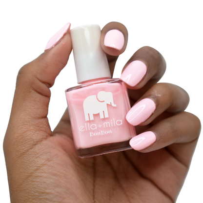 Pucker Up bubblegum pink nail polish on a deep skin tone, hand holding the bottle