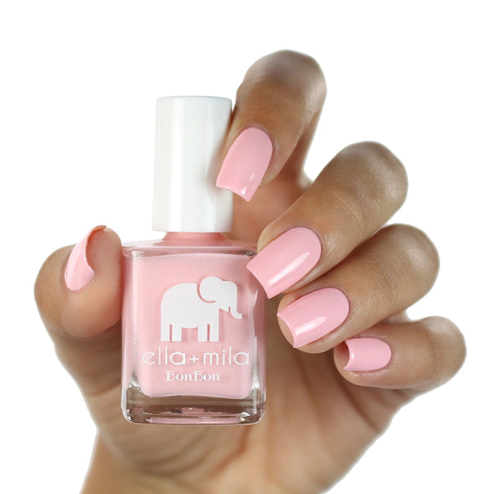 Pucker Up pink nail polish on a medium skin tone, hand holding the bottle