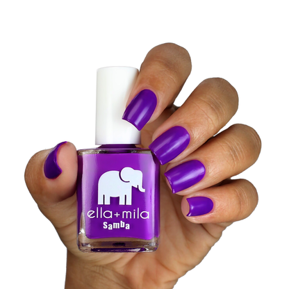 Purple Reign bright purple nail polish on a medium-deep skin tone, hand holding the bottle