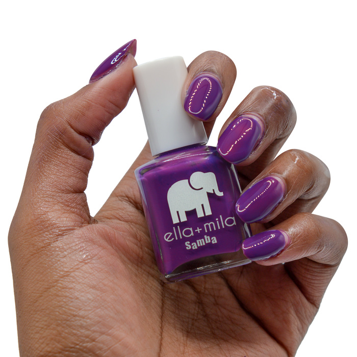Purple Reign bright purple nail polish on a deep skin tone, hand holding the bottle