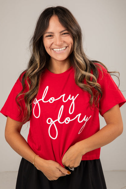 Woman wearing a red t-shirt with 'glory glory' text against a plain background