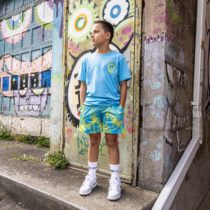 Youth model wearing blue and yellow Retro Graffiti youth shorts