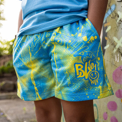 Youth model wearing blue and yellow Retro Graffiti youth shorts
