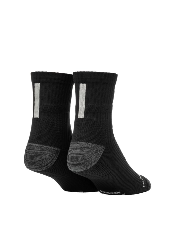 Rear three-quarter view of Selkirk Courtlock pickleball sock showcasing black crew length, gray cushioned heel, and white vertical tab on white background