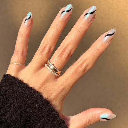 Simple Twist - Press-On | Medium | Almond neutral nails with subtle black swirl design on hand with rings