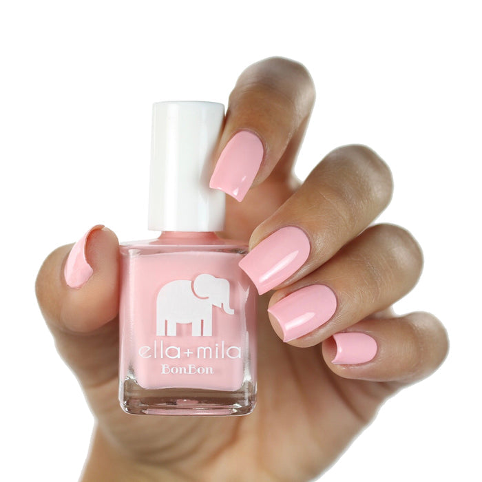 Sugar Puff baby pink nail polish on a medium skin tone, hand holding the bottle