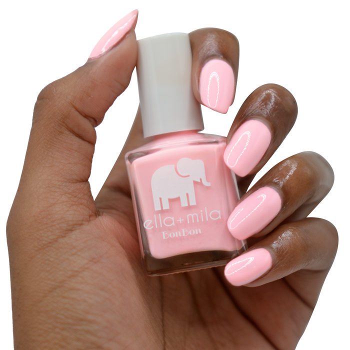 Sugar Puff baby pink nail polish on a deep skin tone, hand holding the bottle