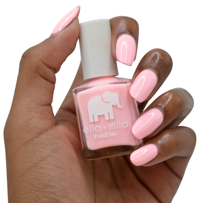 Sugar Puff baby pink nail polish on a deep skin tone, hand holding the bottle