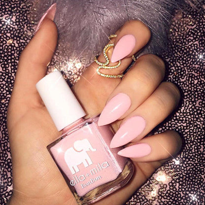 Sugar Puff baby pink almond manicure with a gold ring on a glitter background