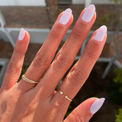Hand with nails painted in soft white Swan polish showcasing a polished quick dry manicure in natural light