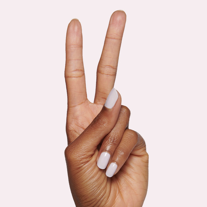 Hand showing two fingers with smooth nails painted in The Usual neutral lavender grey polish for manicure