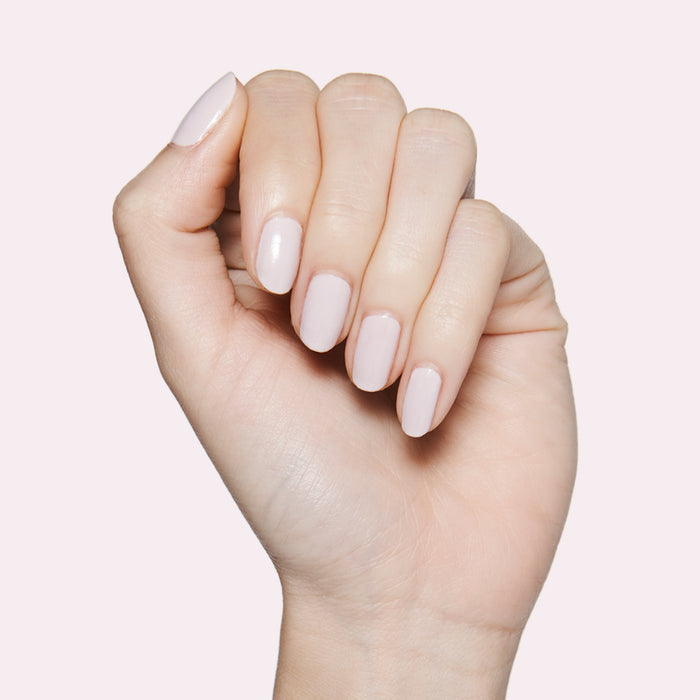 Hand showing nails painted in soft neutral lavender grey The Usual nail polish for a smooth manicure look
