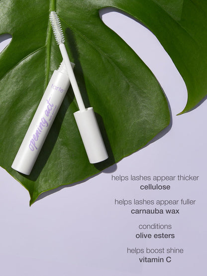 Mascara tube with brush on a green leaf against a light purple background