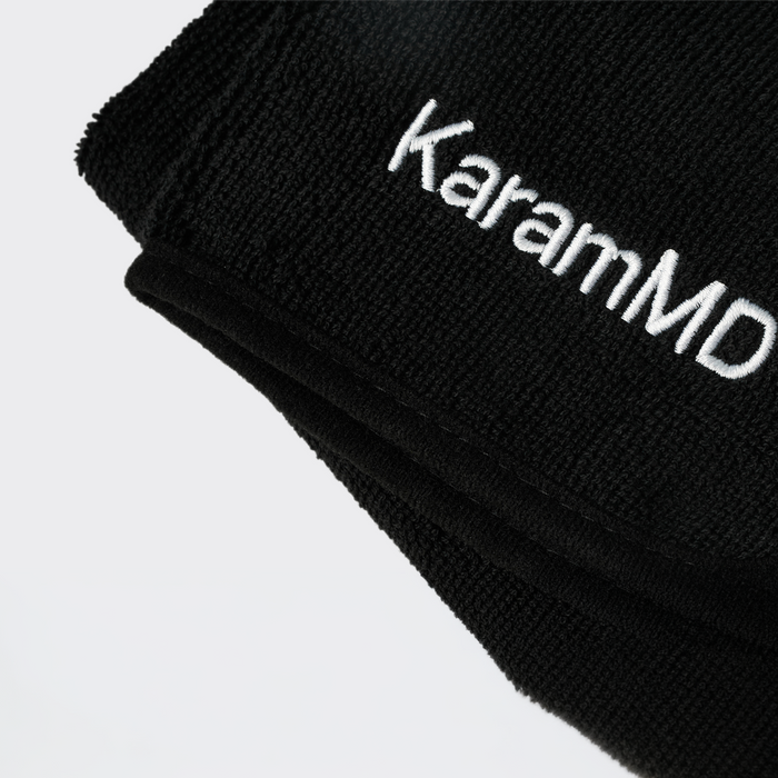 Black face towel with 'KaramMD' embroidered on a light gray background